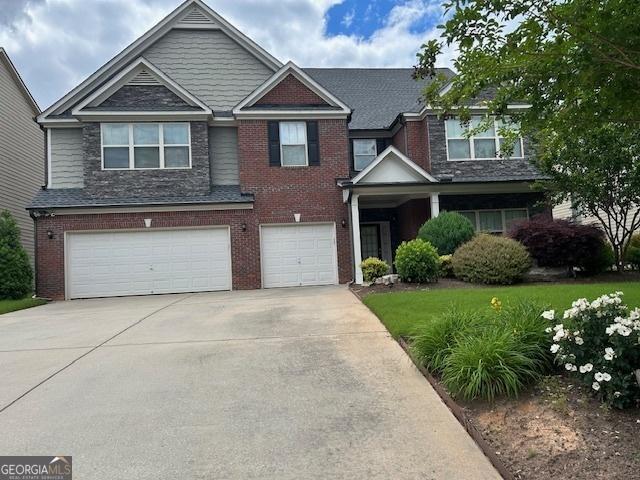 view of front of property with concrete driveway, brick siding, and an attached garage