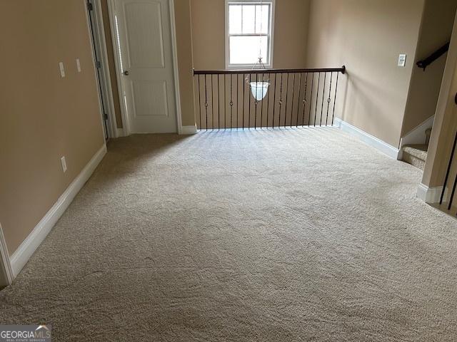 spare room featuring baseboards and carpet
