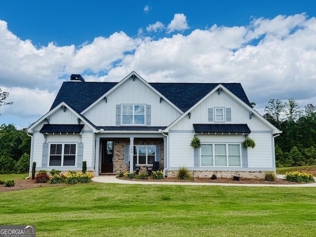 modern farmhouse style home with roof with shingles, a front yard, metal roof, board and batten siding, and a standing seam roof