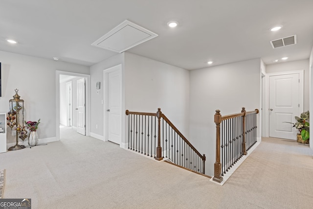 corridor featuring recessed lighting, attic access, carpet flooring, visible vents, and an upstairs landing