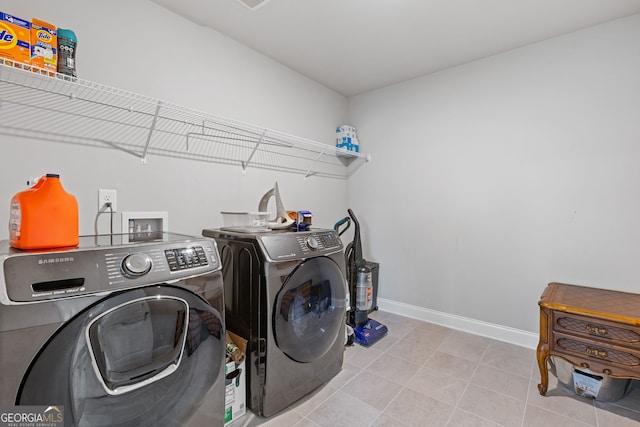 washroom with washer and dryer, laundry area, tile patterned floors, and baseboards
