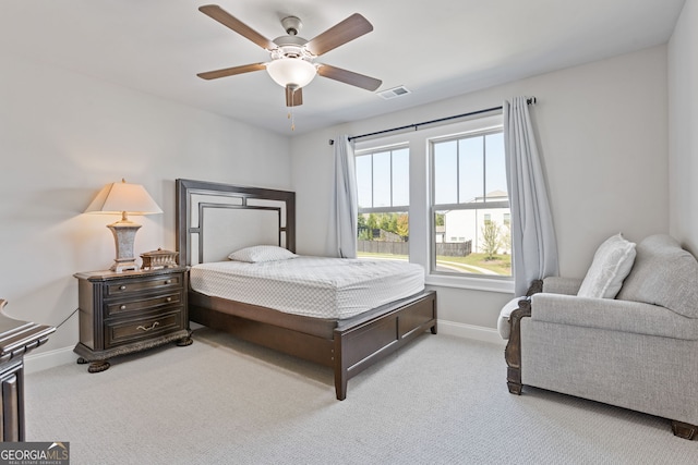 bedroom featuring light carpet, baseboards, a ceiling fan, and visible vents