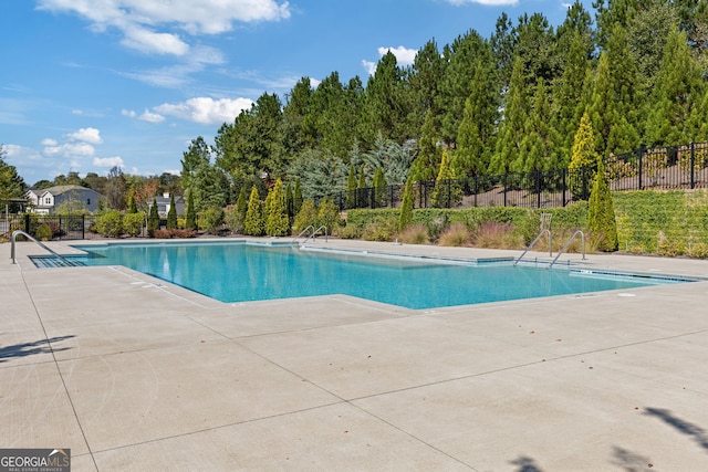 pool with fence and a patio area