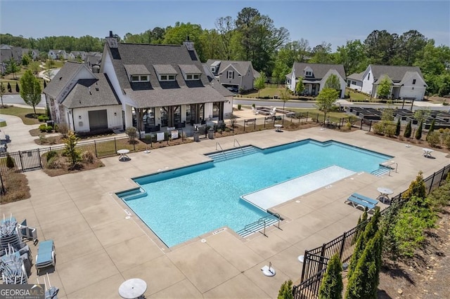 pool featuring a patio area, fence, and a residential view