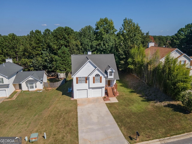 view of front facade featuring fence, an attached garage, a front lawn, and driveway