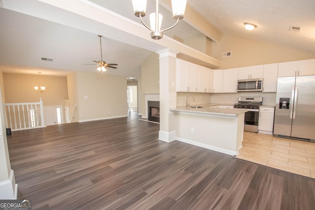 kitchen featuring a sink, stainless steel appliances, ceiling fan with notable chandelier, visible vents, and open floor plan
