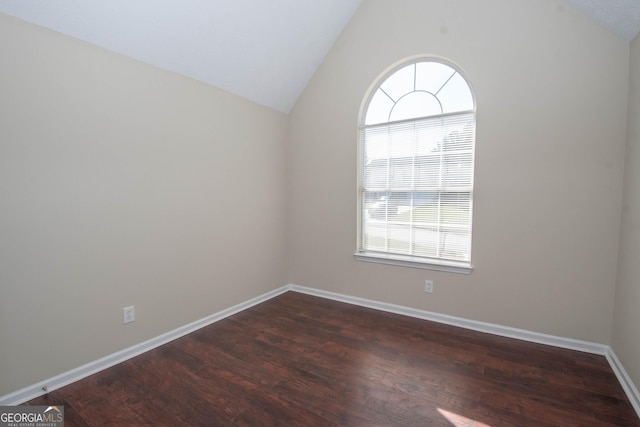 unfurnished room featuring baseboards, wood finished floors, and vaulted ceiling