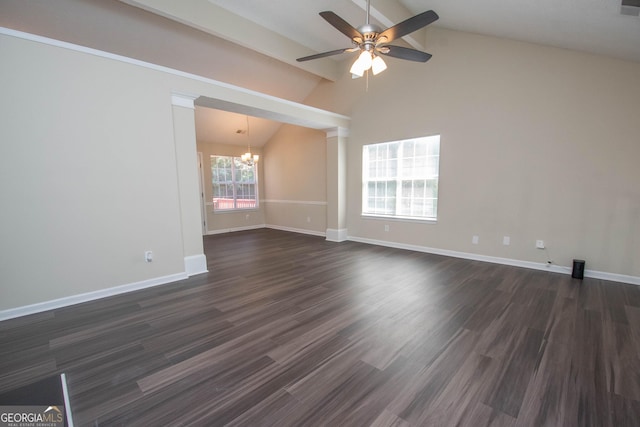 empty room featuring high vaulted ceiling, ceiling fan with notable chandelier, baseboards, and dark wood finished floors