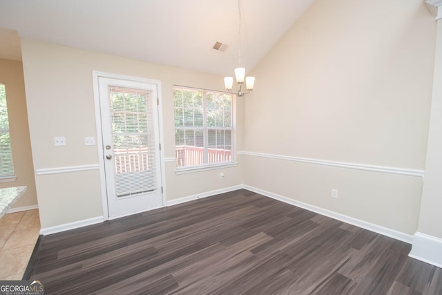unfurnished dining area featuring baseboards, a chandelier, wood finished floors, and vaulted ceiling