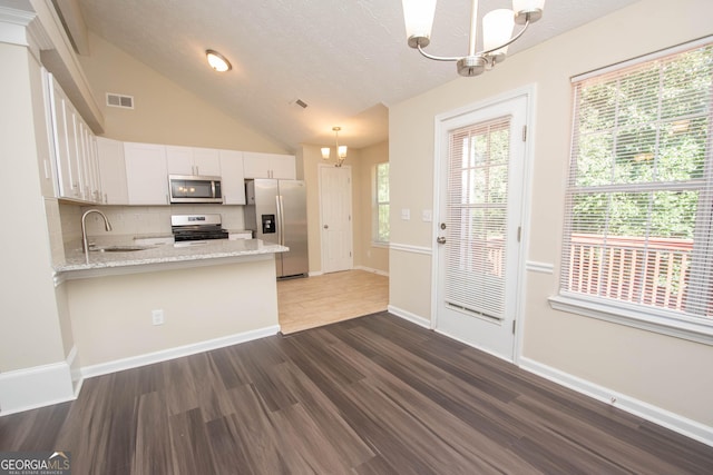 kitchen featuring a chandelier, dark wood-style flooring, decorative backsplash, white cabinets, and appliances with stainless steel finishes