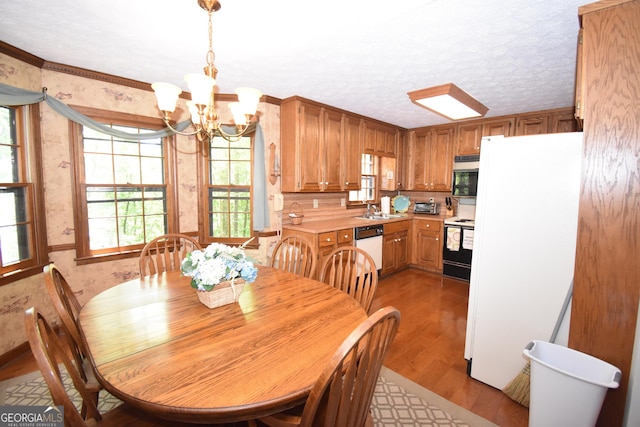 4056 Ryckeley Dr, Gainesville, GA 30504 - dining space featuring a chandelier, ornamental molding, light wood-type flooring, and wallpapered walls