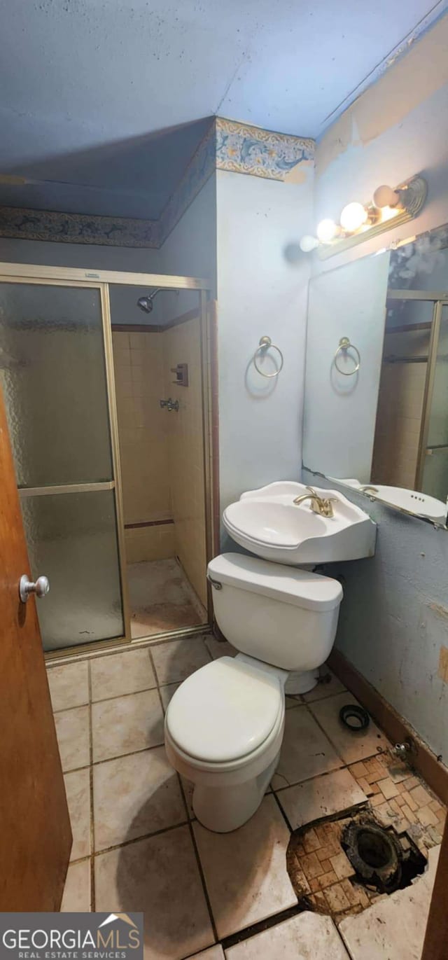 full bathroom featuring tile patterned floors, toilet, and a stall shower