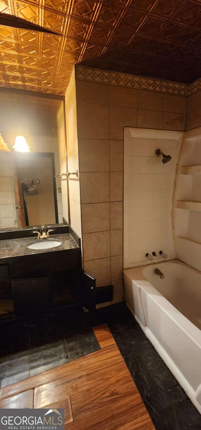 bathroom with an ornate ceiling, vanity, shower / bathing tub combination, and wood finished floors