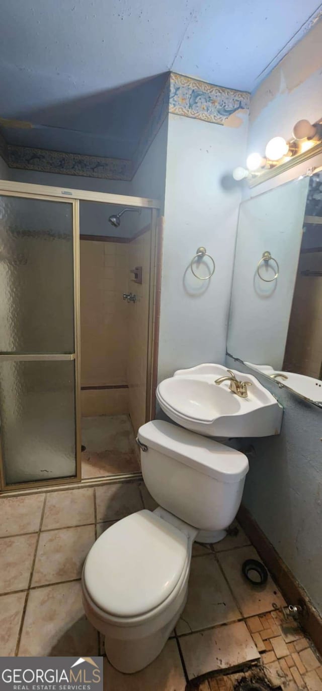 full bath with a stall shower, tile patterned floors, and toilet