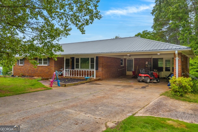 ranch-style home featuring concrete driveway, an attached carport, brick siding, and covered porch