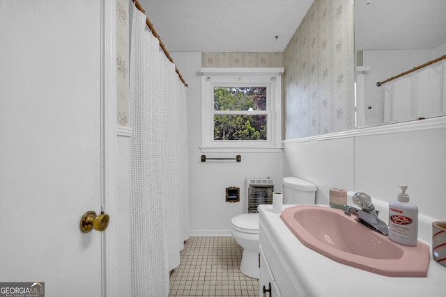 bathroom with toilet, vanity, tile patterned flooring, heating unit, and wallpapered walls