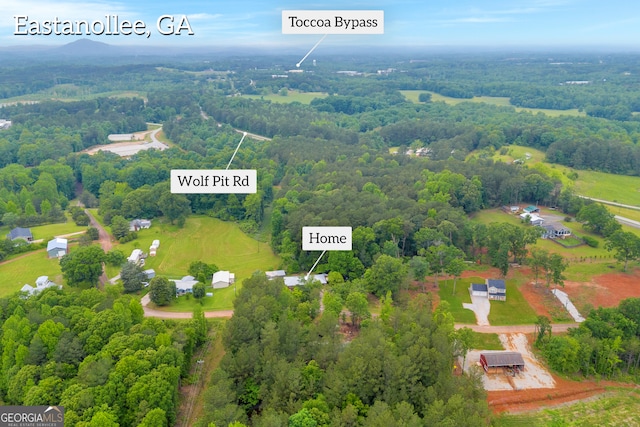 drone / aerial view featuring a wooded view