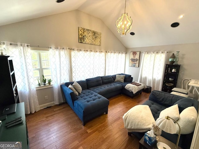 living area with a chandelier, lofted ceiling, and hardwood / wood-style flooring