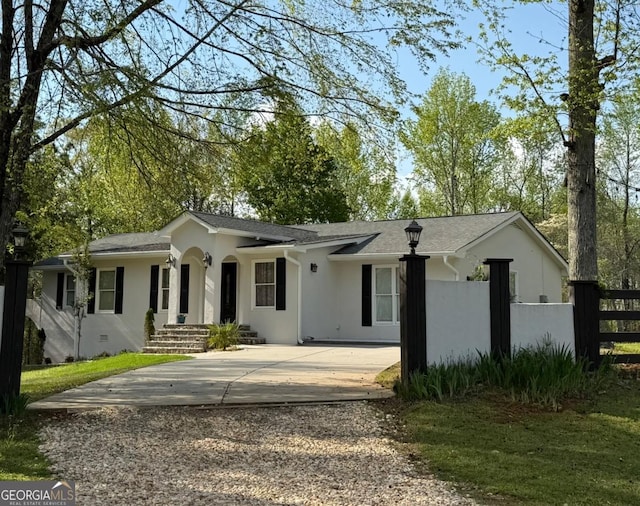 single story home featuring concrete driveway, fence, and stucco siding