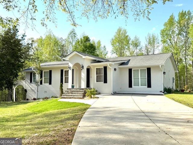 ranch-style home with concrete driveway, stucco siding, and a front yard