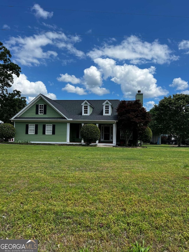 view of front of home with a chimney and a front yard