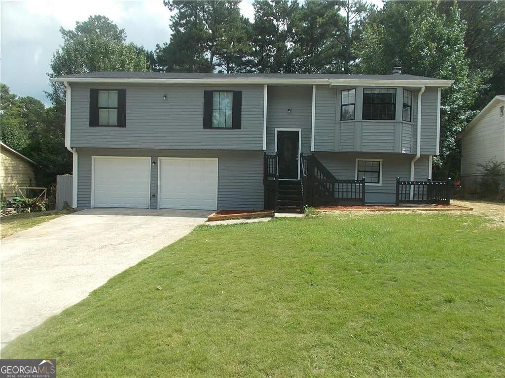 2845 Woodhollow Ln, Jonesboro, GA 30236 - raised ranch with concrete driveway, a front yard, and an attached garage