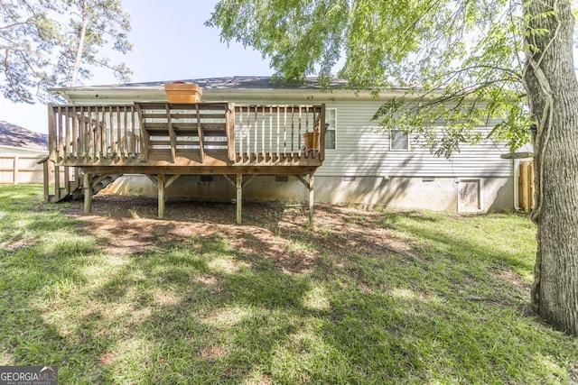 rear view of house featuring a wooden deck and a lawn