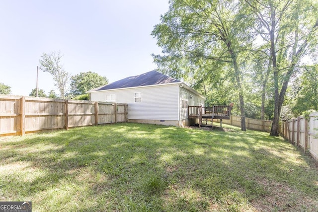 view of yard with a wooden deck and a fenced backyard