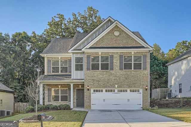craftsman house with brick siding, driveway, fence, and a front yard