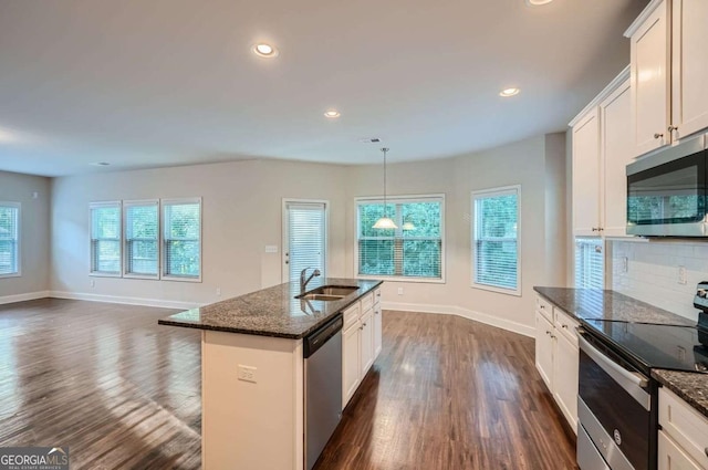 kitchen with a wealth of natural light, appliances with stainless steel finishes, dark wood-type flooring, and a sink