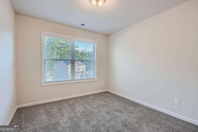 carpeted spare room with baseboards and visible vents
