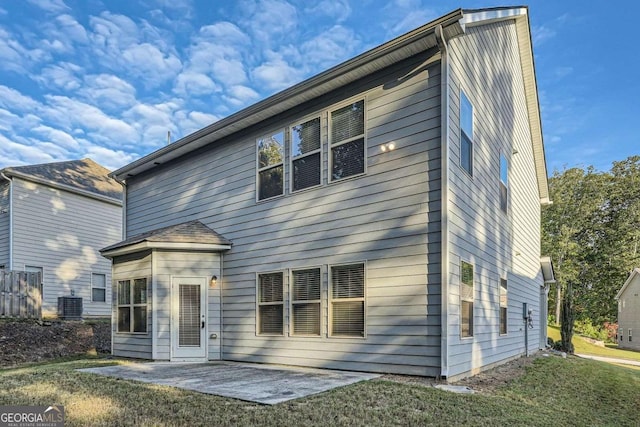 back of house with a patio, a lawn, and central AC