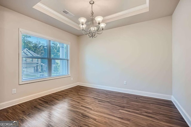 spare room featuring ornamental molding, baseboards, dark wood finished floors, a raised ceiling, and a notable chandelier