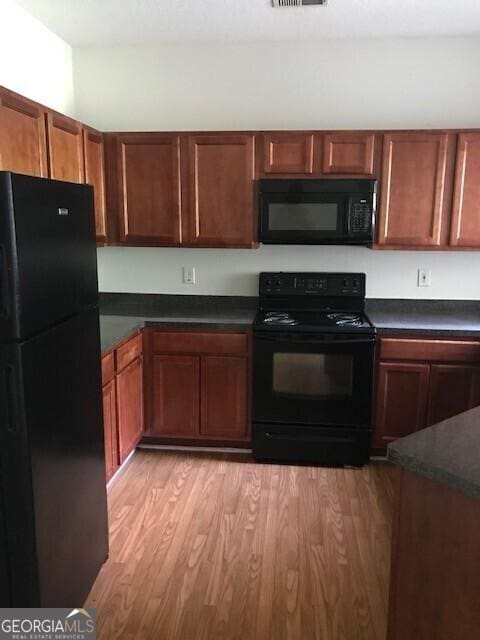 2320 Coach Way, Jonesboro, GA 30236 - kitchen featuring black appliances, light wood finished floors, and dark countertops