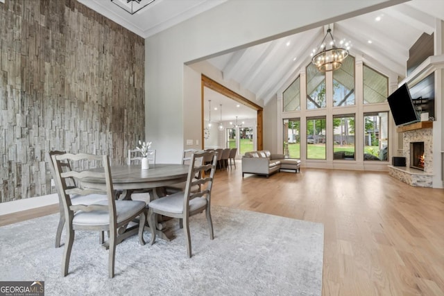 852 Tom Miller Rd, Bethlehem, GA 30620 - dining room featuring wood finished floors, high vaulted ceiling, beam ceiling, a notable chandelier, and a stone fireplace