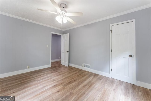 unfurnished bedroom with light wood-style flooring, visible vents, baseboards, ceiling fan, and ornamental molding