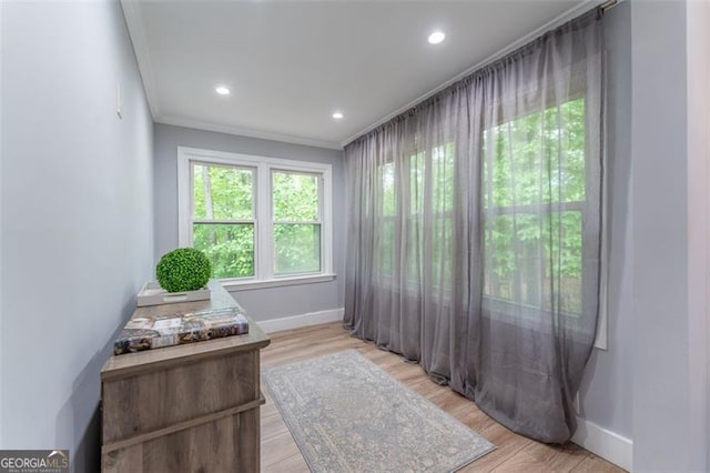 interior space featuring light wood finished floors, ornamental molding, baseboards, and recessed lighting