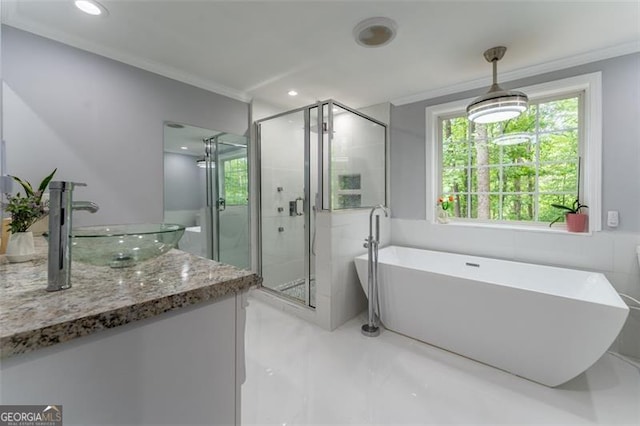 full bath featuring marble finish floor, vanity, crown molding, a shower stall, and a soaking tub