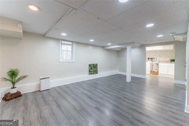 basement featuring baseboards, recessed lighting, and wood finished floors