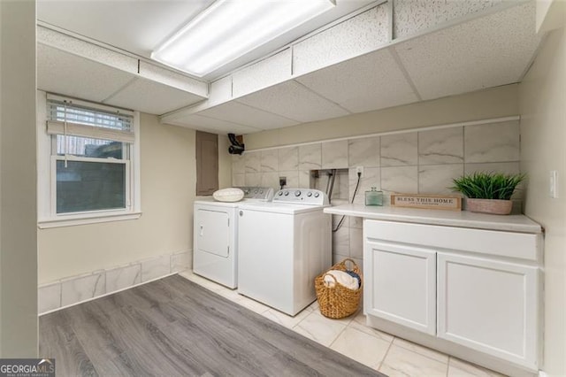 washroom featuring washing machine and clothes dryer and cabinet space