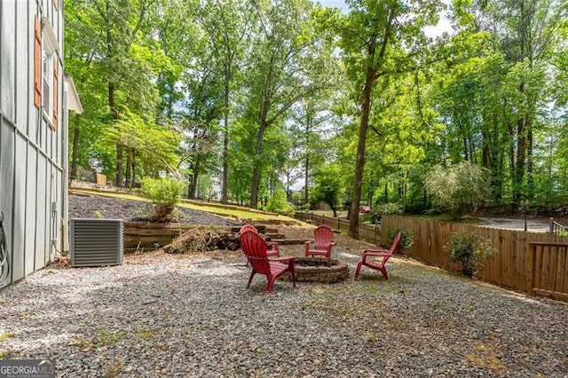 view of yard with fence, a fire pit, and cooling unit