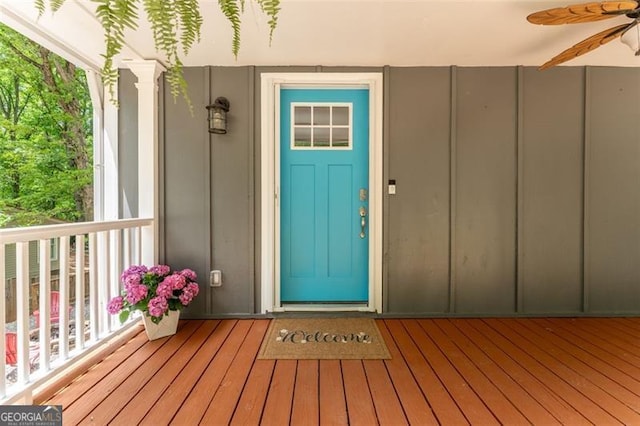 entrance to property with board and batten siding and ceiling fan