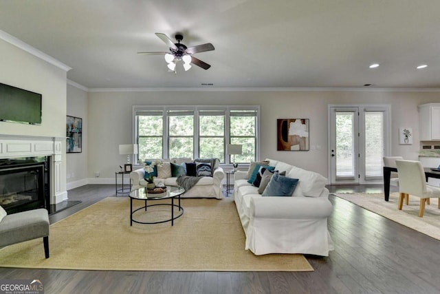 living room with plenty of natural light, crown molding, ceiling fan, wood finished floors, and recessed lighting