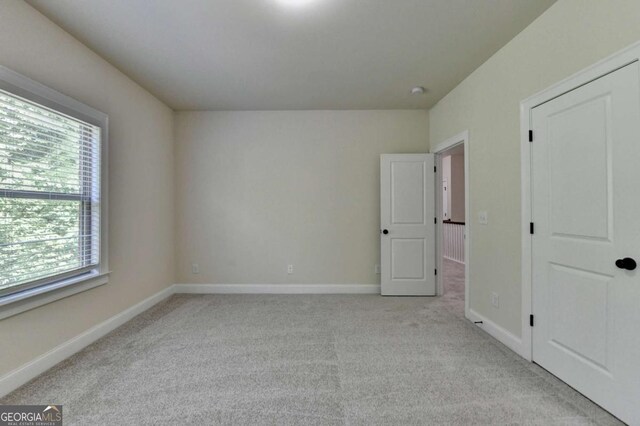 unfurnished bedroom featuring carpet and baseboards