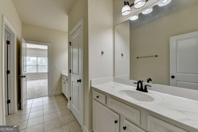 bathroom with vanity, tile patterned flooring, and baseboards