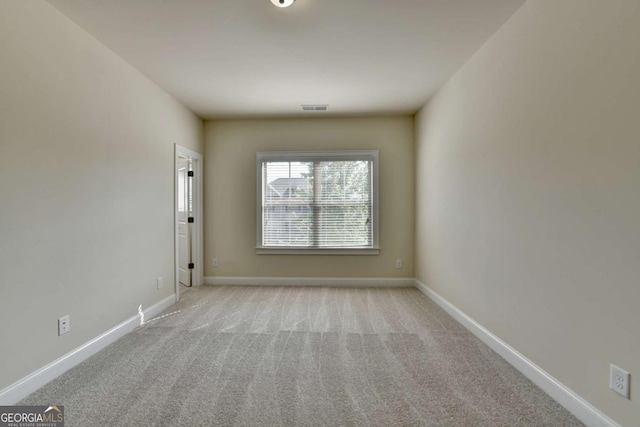 carpeted spare room featuring baseboards