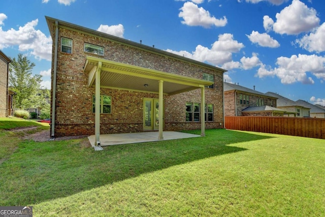 rear view of property featuring a patio and brick siding