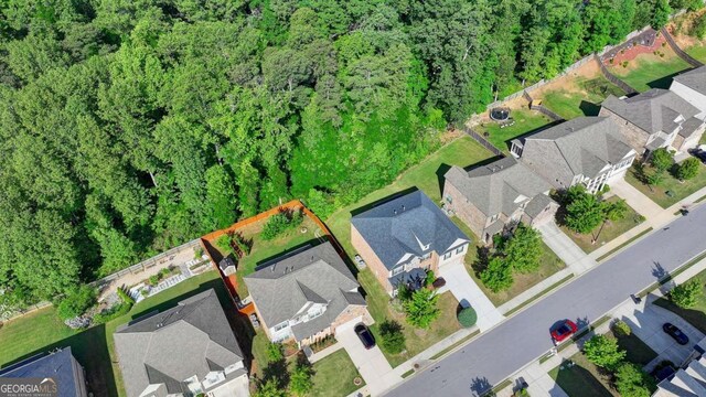 aerial perspective of suburban area featuring a heavily wooded area