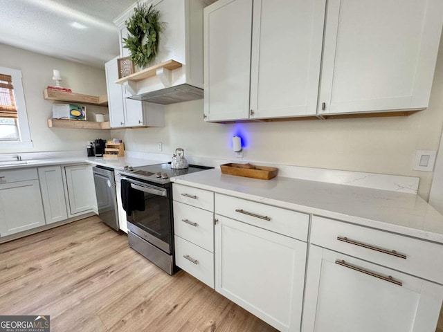 801 W Grossman Dr, Vidalia, GA 30474 - kitchen featuring stainless steel appliances, open shelves, light wood-style floors, light countertops, and wall chimney exhaust hood