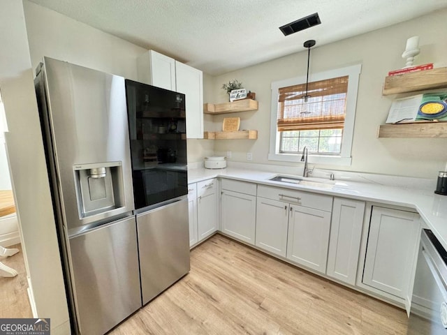 801 W Grossman Dr, Vidalia, GA 30474 - kitchen featuring stainless steel appliances, open shelves, light wood-style flooring, light countertops, and a sink